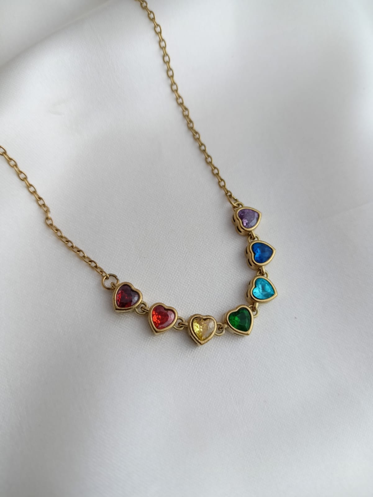 Necklace with heart-shaped colorful gemstones on a white background